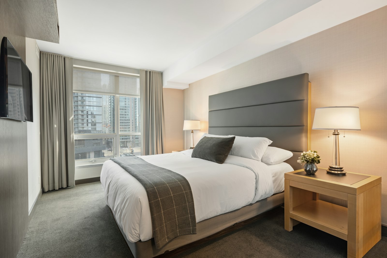 Standard Room — crisp white queen bed, pale walls and soft daylight